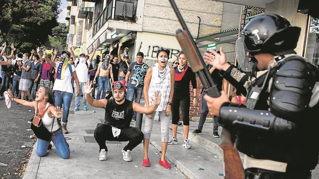 Miembros de la Policía Nacional Bolivariana se enfrentan a manifestantes en Caracas
